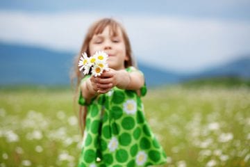 a girl holding up flowers